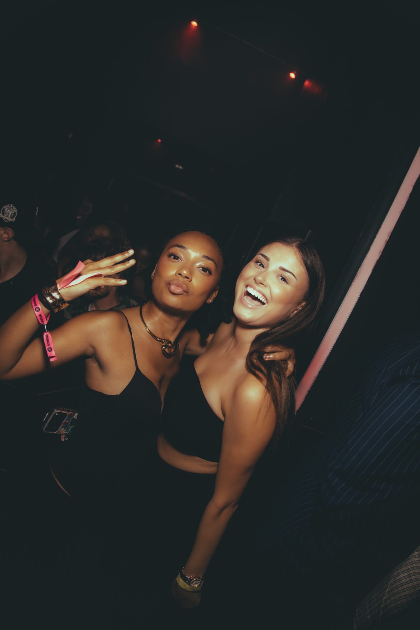 Deux amies riant et faisant un baiser, bracelets de soirée aux poignets