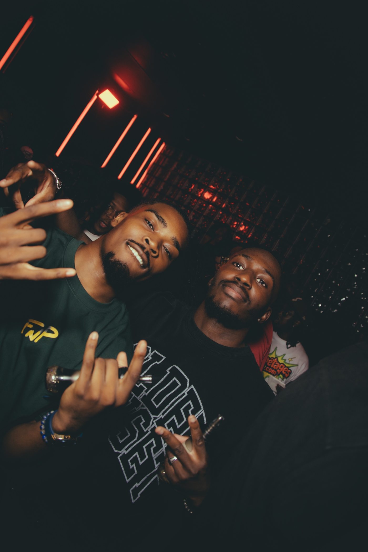 Deux amis qui posent, mains en l'air, t-shirts vert et noir