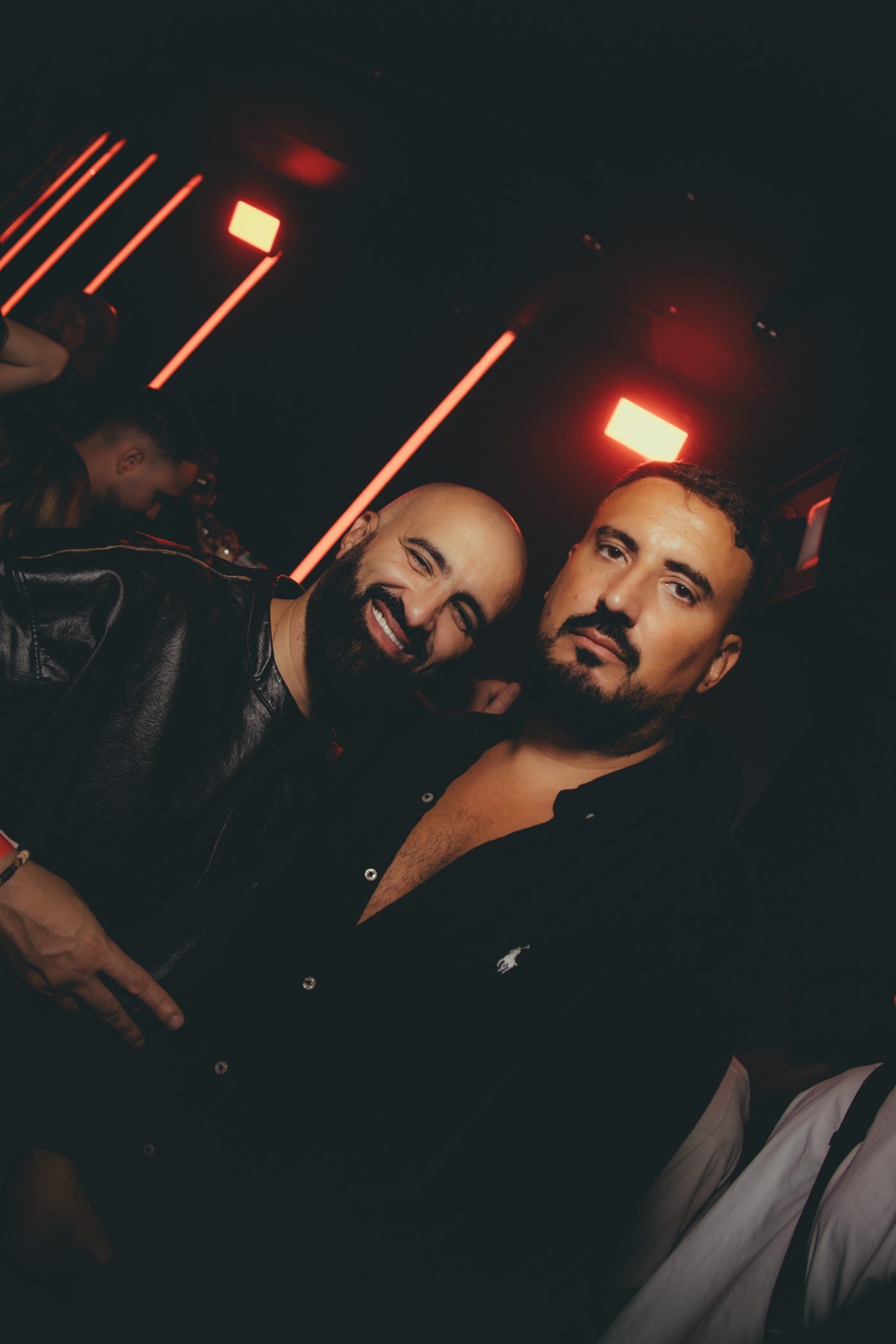 Deux hommes barbus qui posent ensemble, l'un souriant, l'autre le regard sérieux