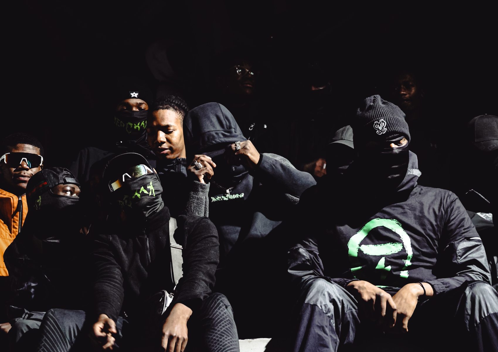Groupe assis dans l'ombre, masques verts et lunettes de sport