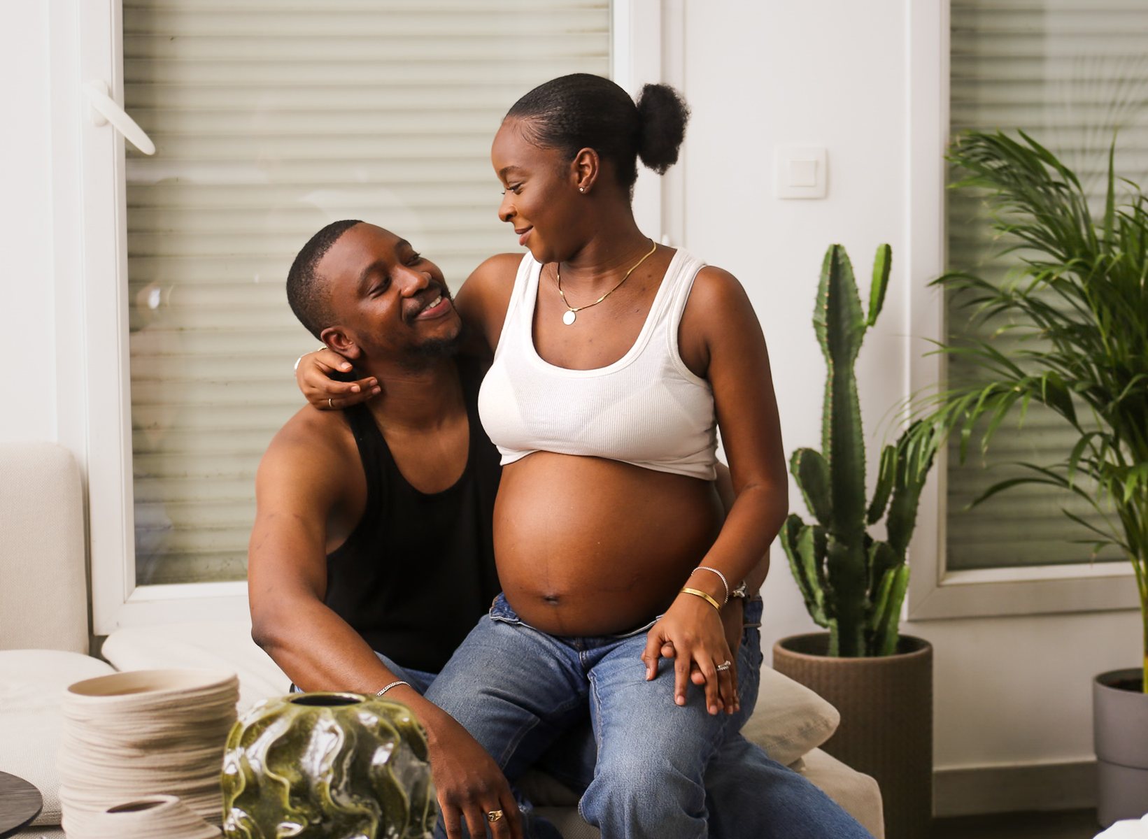 Couple complice à la maison, sourires, plantes vertes