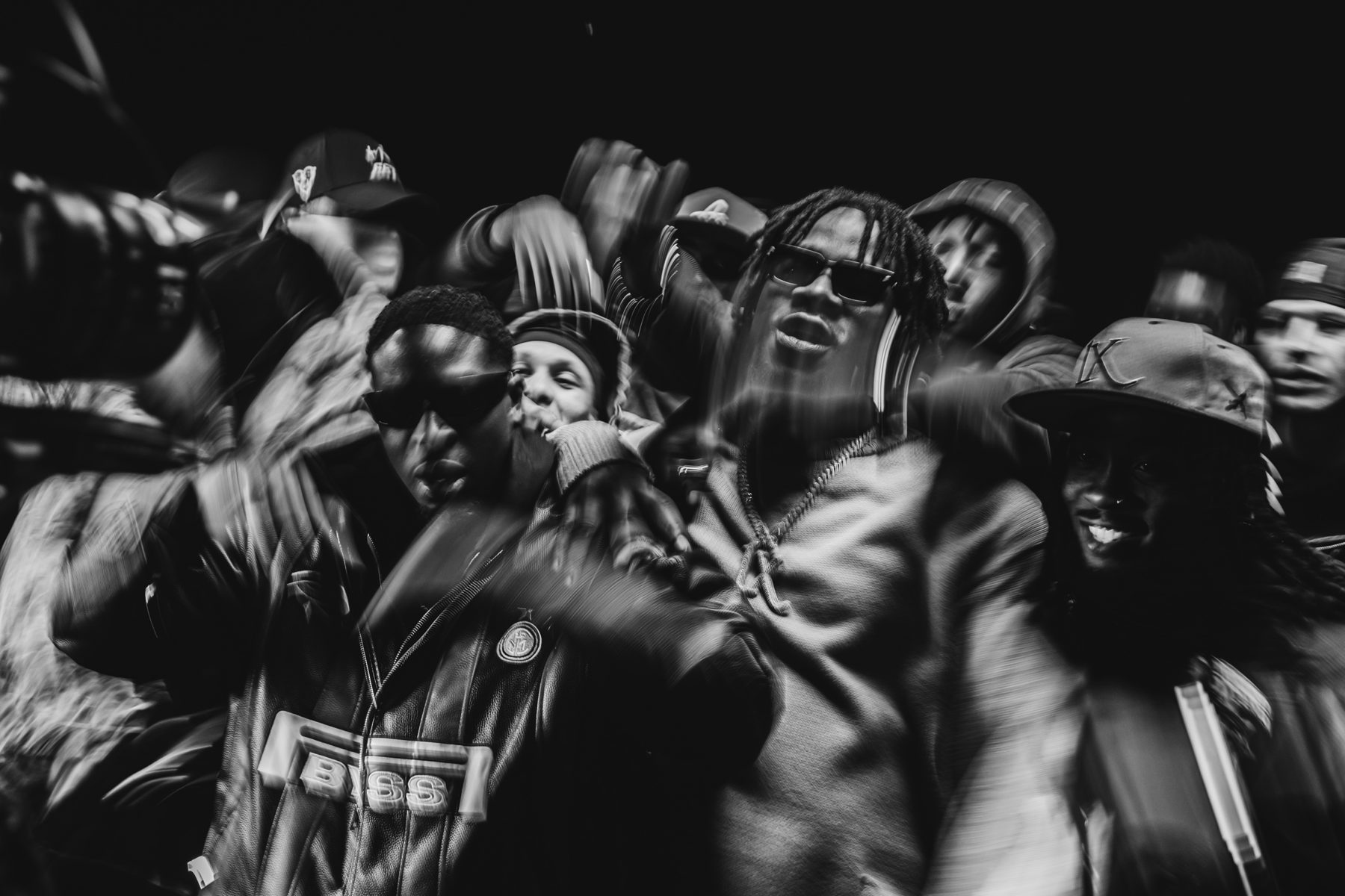 Photo en mouvement : l'équipe danse autour de l'artiste, flou de bougé