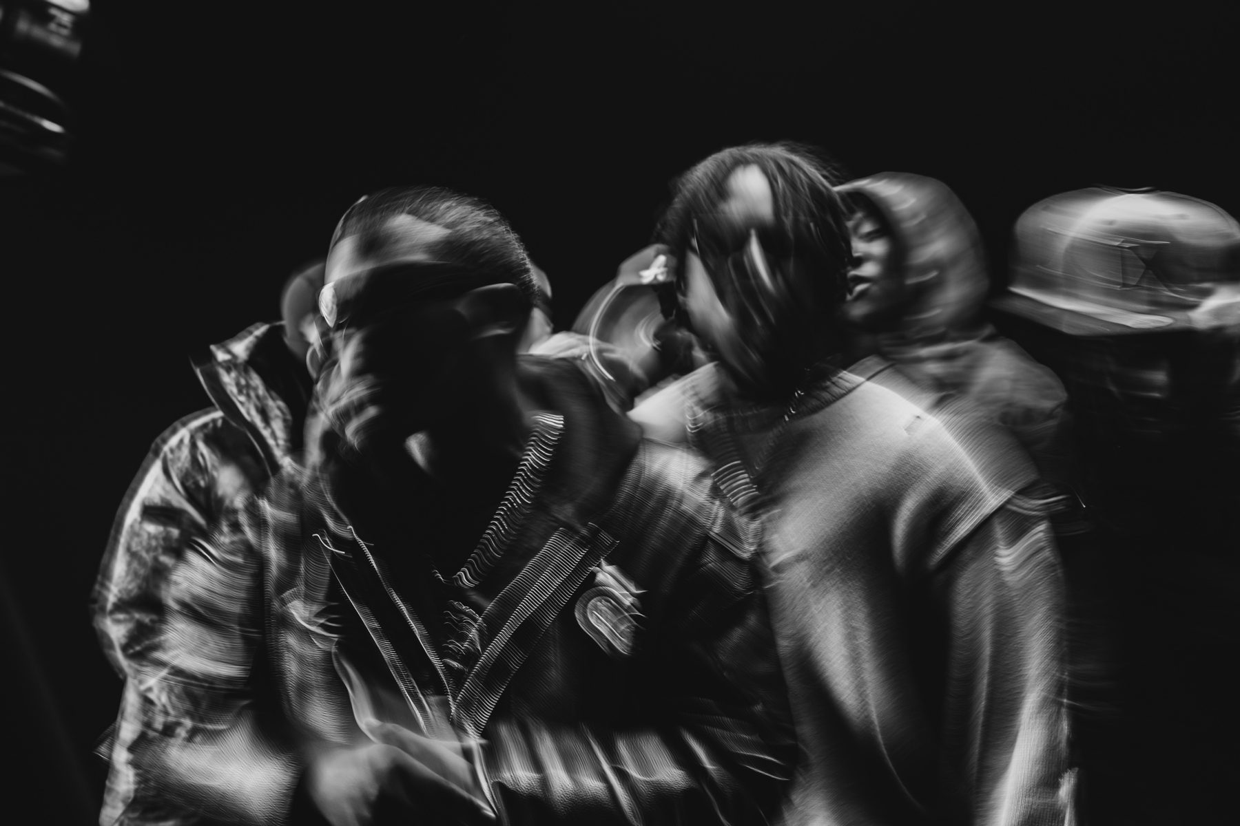 Photo en mouvement : silhouettes floues sur fond noir