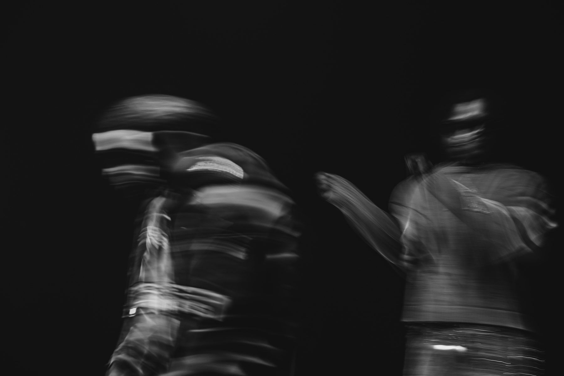 Deux silhouettes floues en mouvement sur fond noir