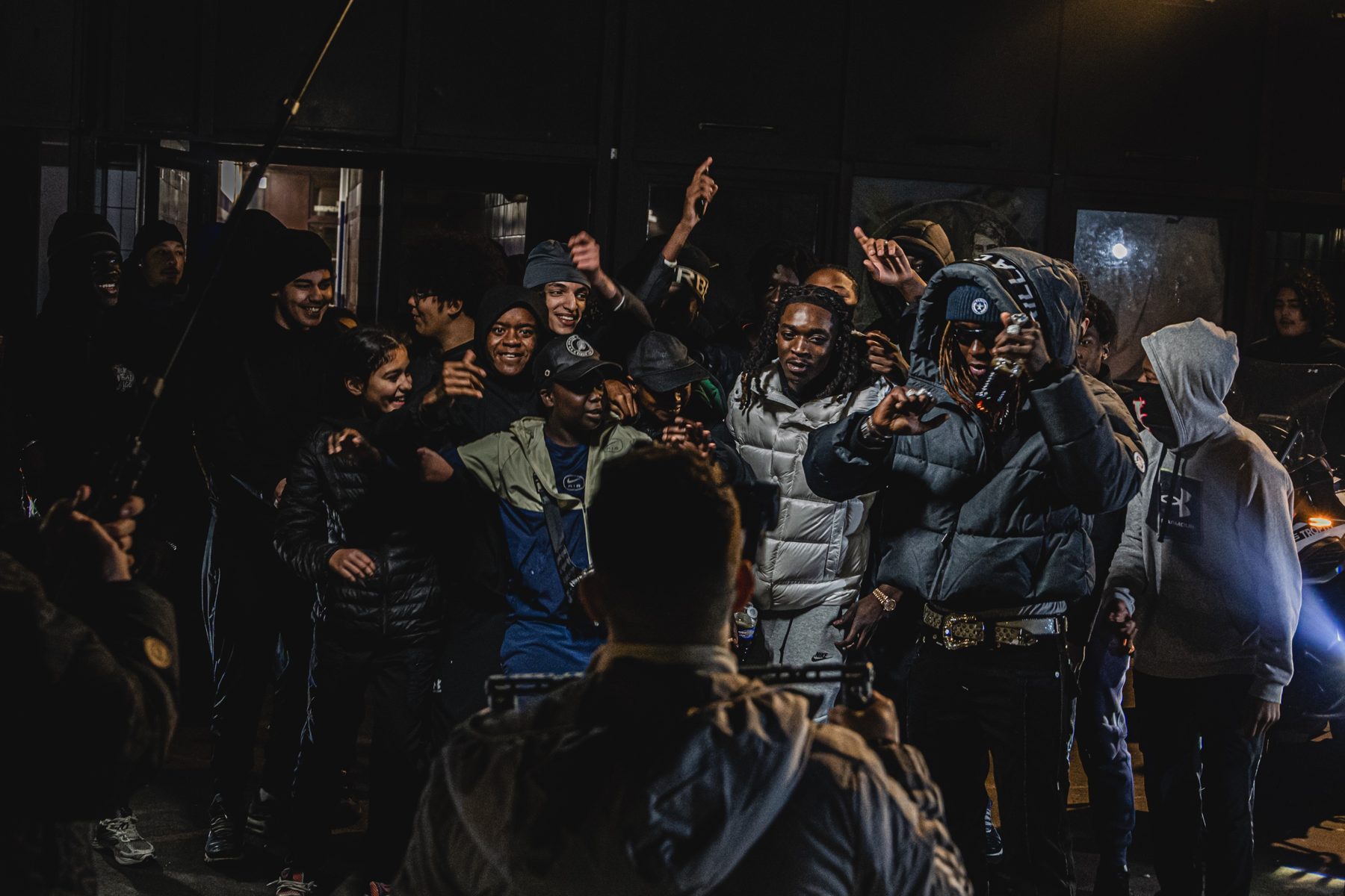 Foule en liesse autour des artistes, perche son en haut à gauche, cadreur de dos