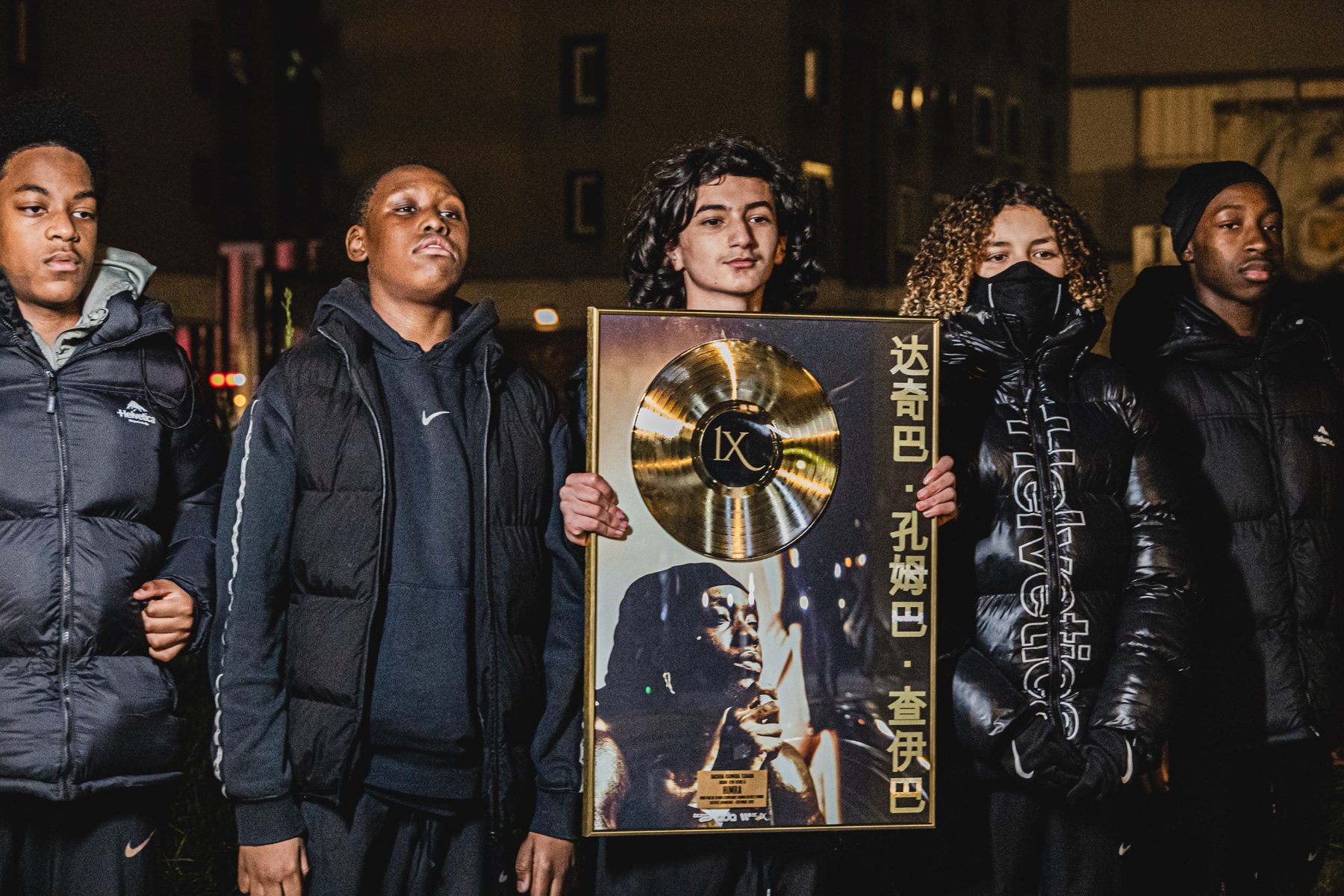 Portrait de groupe avec le disque d'or encadré, doudounes noires